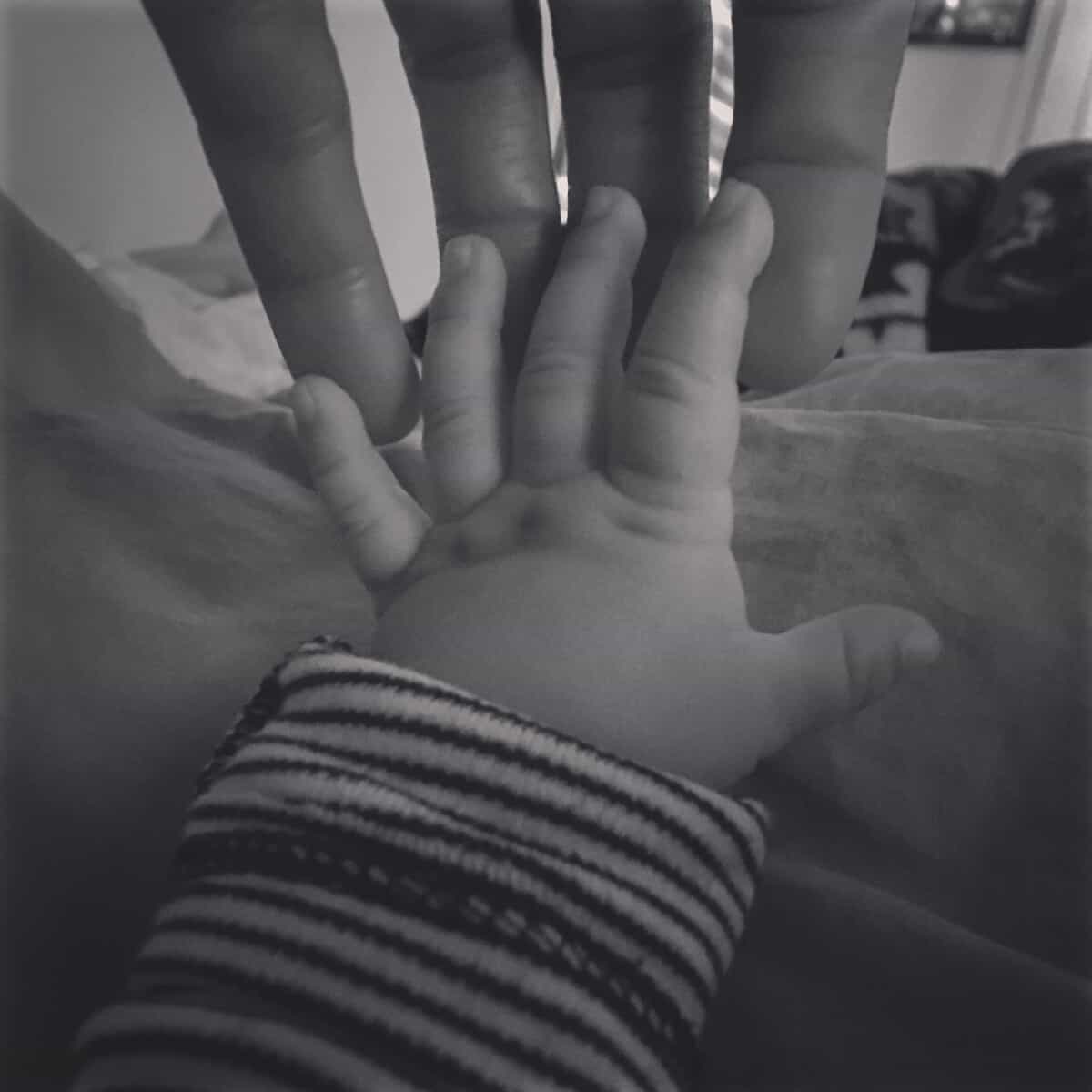 babys fingers touching parent fingers